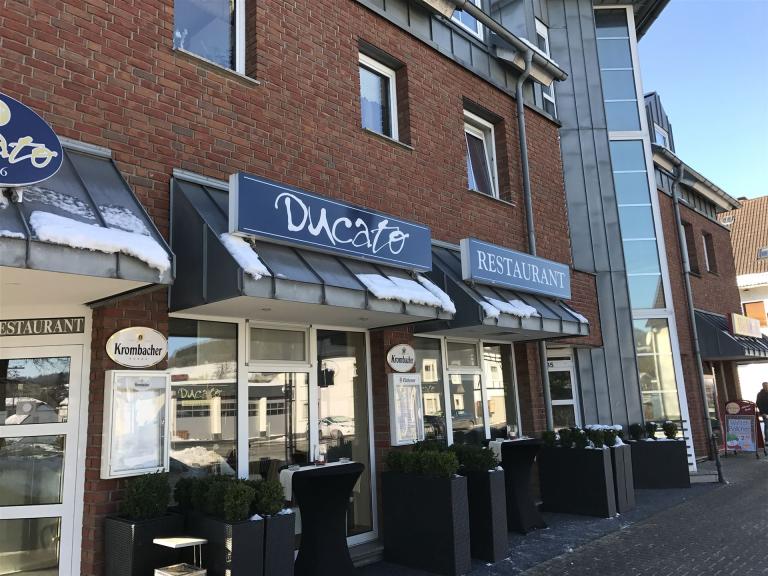 Bild zeigt eine Außenaufnahme vom Restaurant bei schönem Wetter. Man sieht die Frontseite rechts vom Eingang