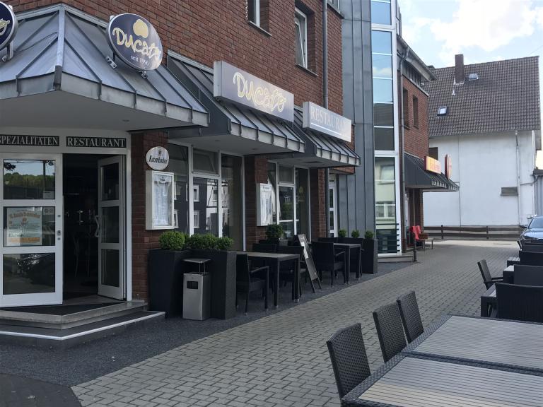 Bild zeigt eine Außenaufnahme vom Restaurant bei schönem Wetter. Man sieht die Frontseite rechts vom Eingang