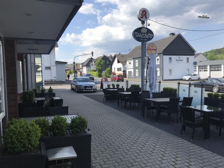 Bild zeigt eine Außenaufnahme vom Restaurant bei schönem Wetter. Man sieht auch die Hauptstraße richtung Krombach