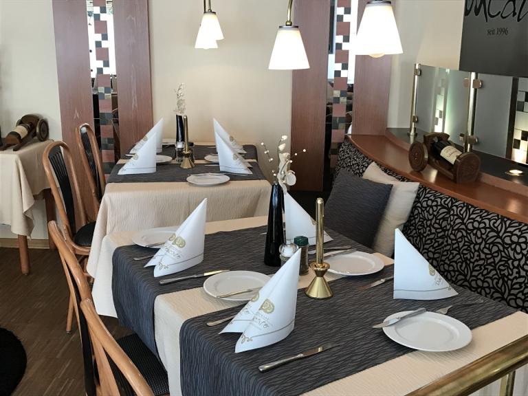 Bild zeigt einen Teil des Restaurant. Zu sehen sind 2 eingedeckte Tische 