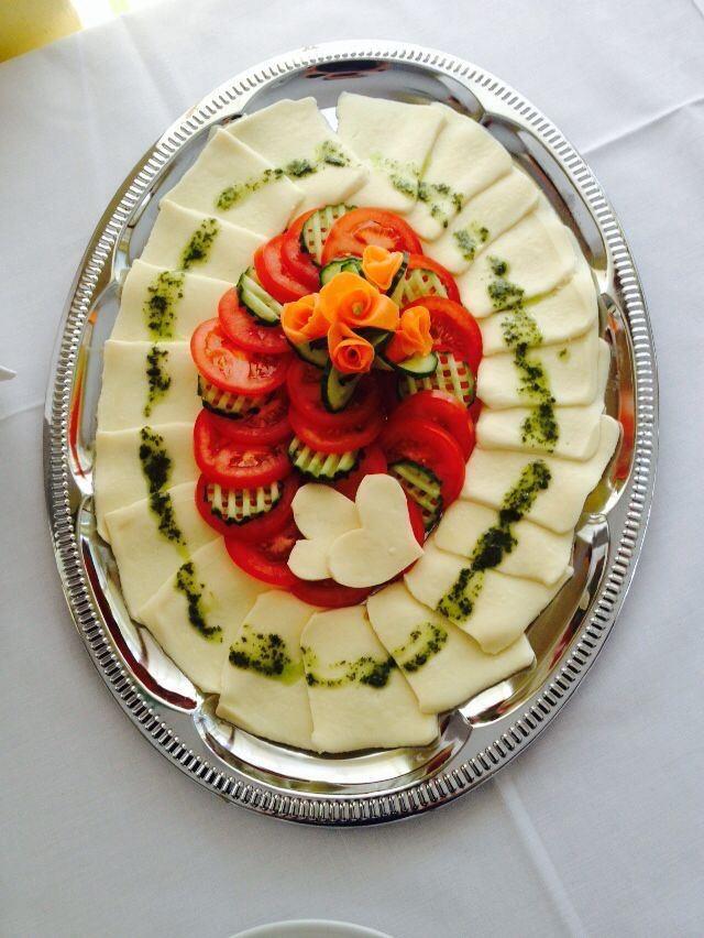 Das Bild zeigt eine Schale mit Tomaten und Mozarellascheiben belegt
