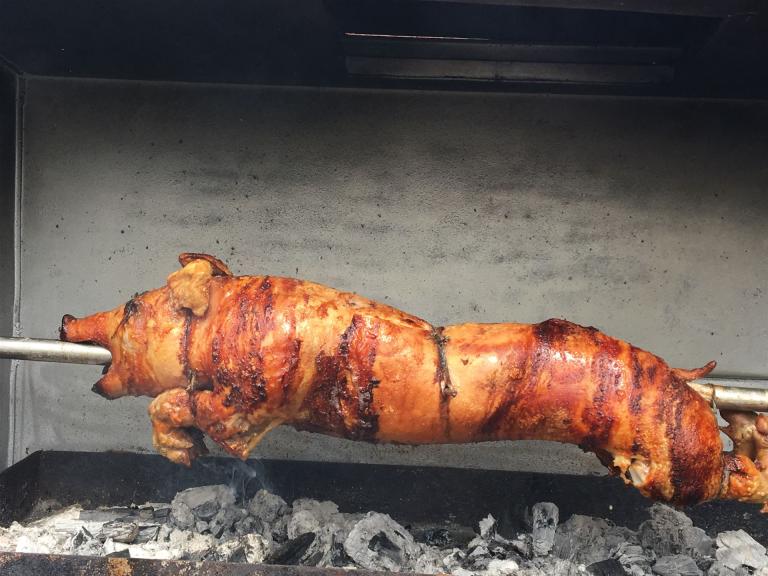 Bild zeigt einen Spanferkel, gegrillt am Drehspieß